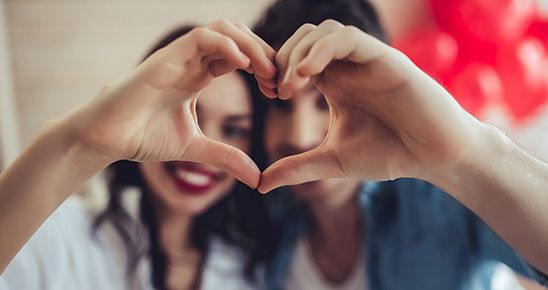 Homme et femme faisant un cœur avec leurs mains